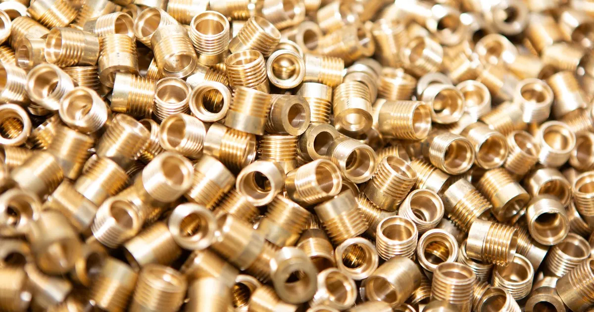 Pile of small threaded brass fittings, the kind of turned part made from brass c360 machining bar